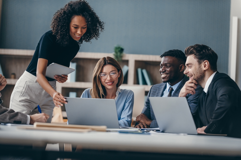 Diverse business team collaborating in an office, representing labor supply and demand dynamics in the modern workforce.